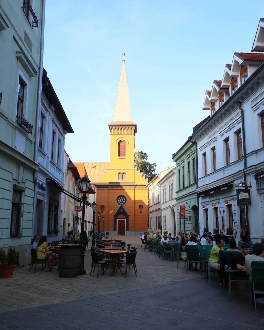 Hlavná ulica v Košiciach s kaviarňami a vežou kostola